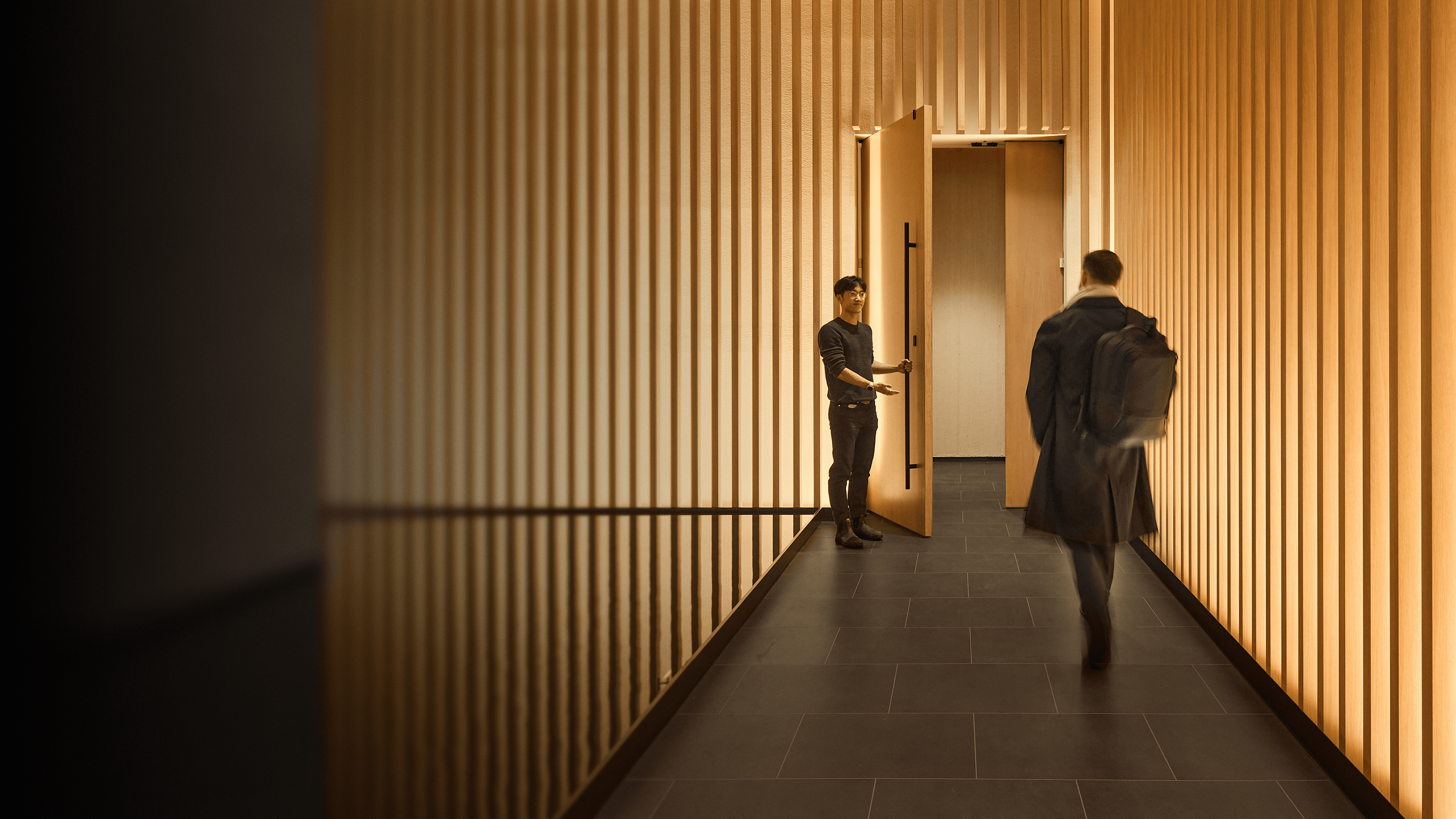 Biograph clinic hallway with warm wood-slat walls.